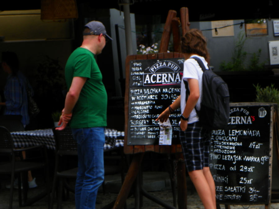 Turyści przeglądają menu Pizza Pub Acerna's